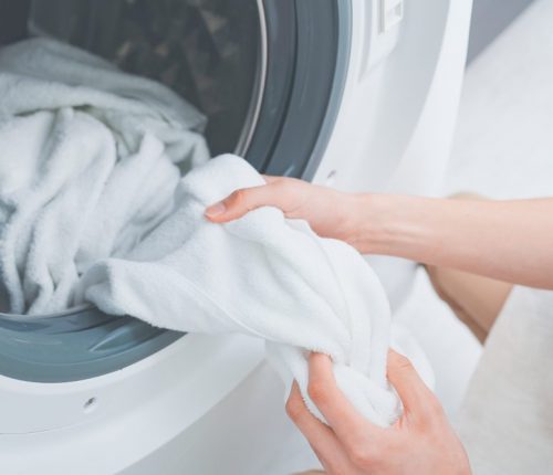 Man,Wearing,Apron,Doing,Laundry