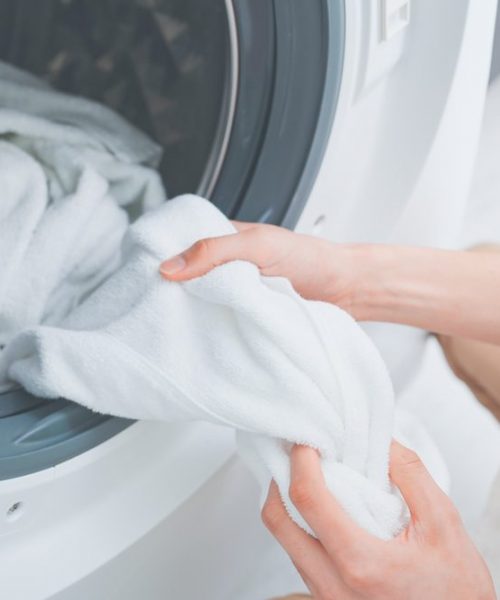 Man,Wearing,Apron,Doing,Laundry