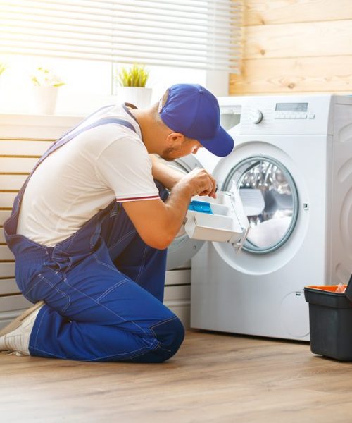 Working,Man,Plumber,Repairs,A,Washing,Machine,In,Laundry