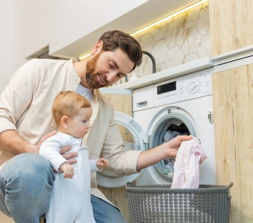 Young,Man,And,His,Little,Son,Sorting,Clothes,Before,Putting