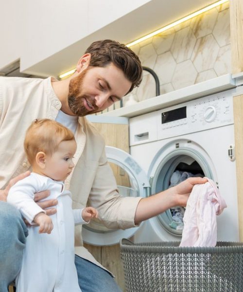 Young,Man,And,His,Little,Son,Sorting,Clothes,Before,Putting