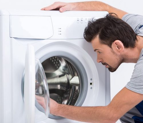 Repairman,Is,Repairing,A,Washing,Machine,On,The,White,Background.