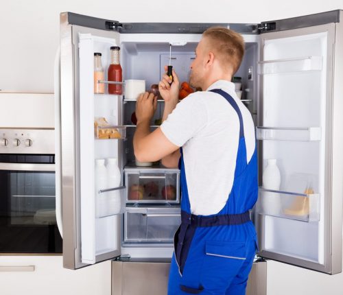 Male,Technician,Repairing,Broken,Refrigerator,Appliance,With,Screwdriver
